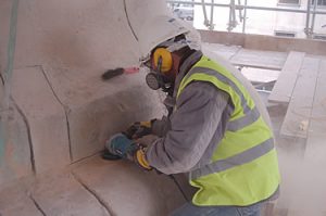 Removing old cement pointing at the base of the column of the Monument