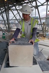 Stonemason using a template to mark the stones prior to his initial cut